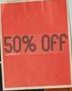 Woman holding a vibrant 50% off shopping bag, promoting sales and discounts indoors.